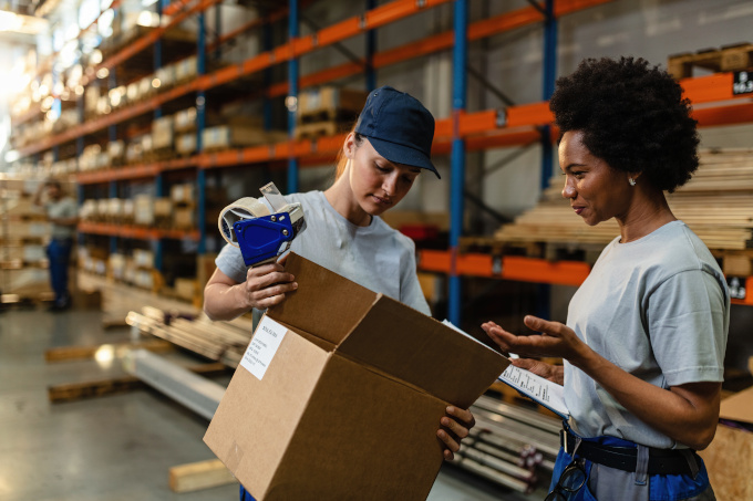 Zwei junge Frauen im Lager mit Paket